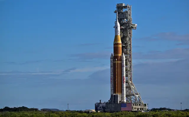 Artemis II Moon rocket being transported across a field at Kennedy Space Center in Florida