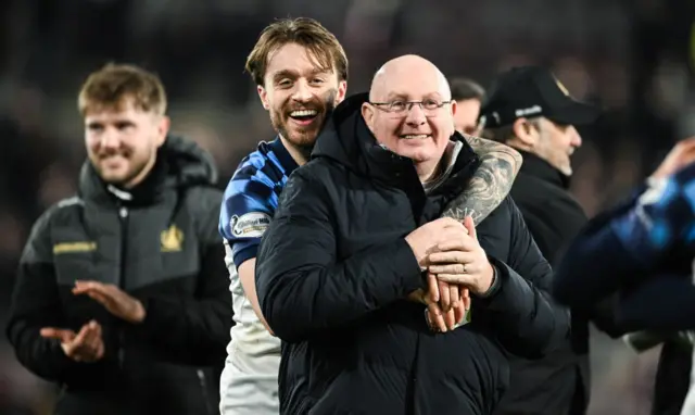 Brad Spencer hugs John McGlynn after the full-time whistle