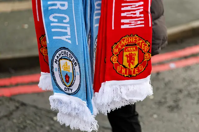 Half and half Manchester United v Manchester City scarves being sold at a merchandise