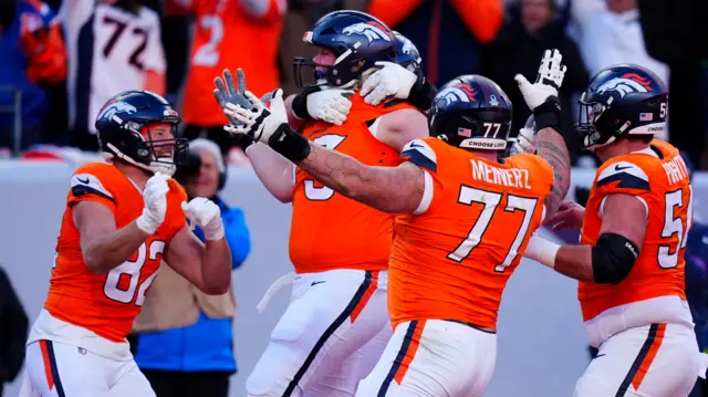 Denver Broncos offensive tackle Frank Crum celebrates with team-mates after scoring a touchdown against the Buffalo Bills