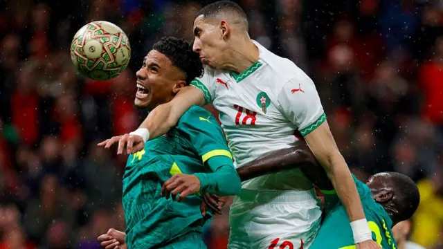Morocco and Senegal players compete for the ball