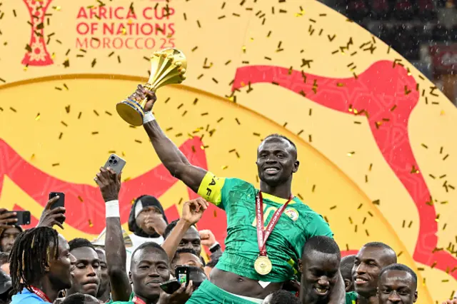 Sadio Mane holds up the trophy as he celebrates