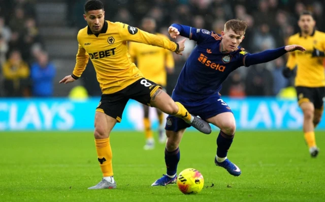 Wolverhampton Wanderers' Joao Gomes (left) and Newcastle United's Lewis Hall battle for the ball
