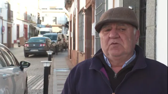 Angel Vendor wearing a brown cap as he speaks to the media in the street