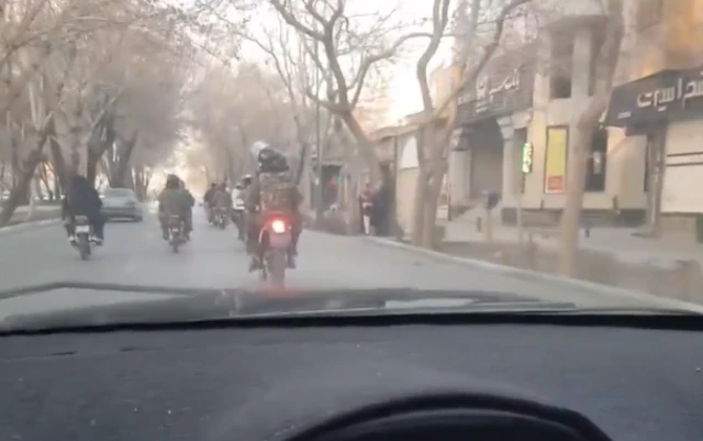Men on motorcycles in Isfahan, one of them with what appears to be a weapon