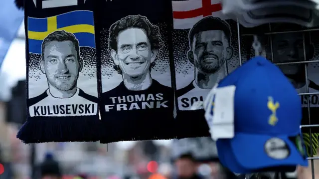 Dejan Kulusevski, Thomas Frank and Dominic Solanke's respective faces on Tottenham scarves outside the stadium.