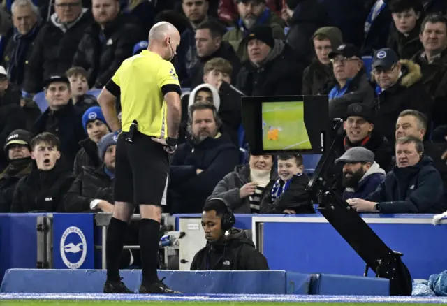 Referee Paul Tierney looks at the VAR monitor before awarding a penalty to AFC Bournemouth