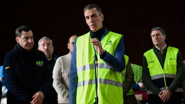 Sanchez holding a microphone and speaking during the conference