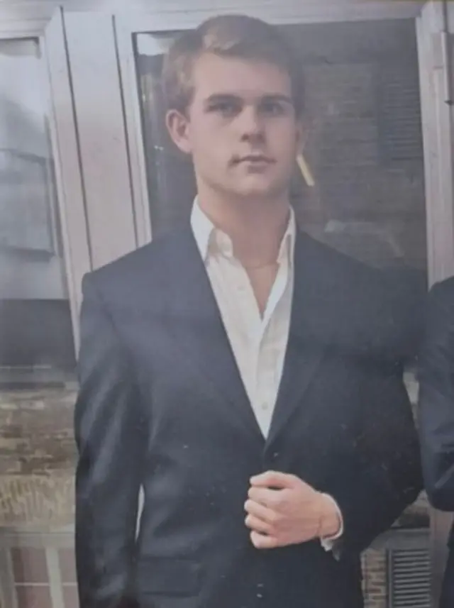 Achille Barosi in a suit, looking at the camera