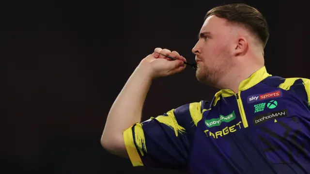 Luke Littler throws a dart