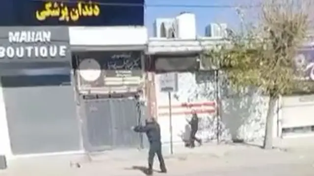 A screengrab from a video showing two men in uniform apparently firing pump-action shotguns
