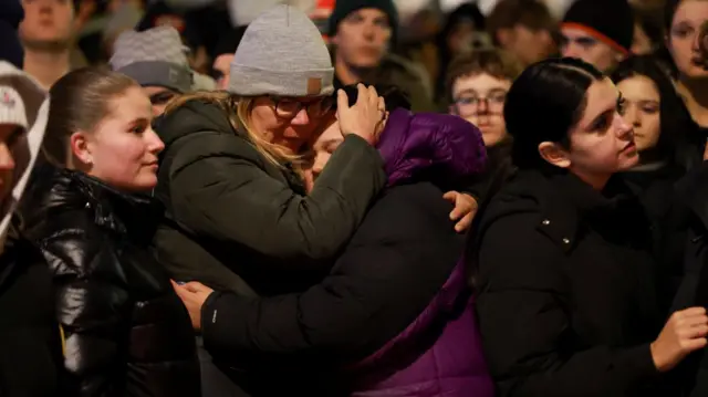 People embrace outside the "Le Constellation" bar
