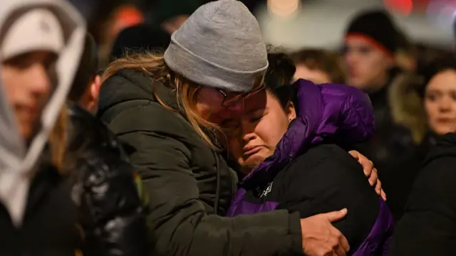 Mourners comfort one another at the scene