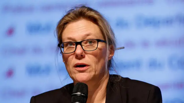 Beatrice Pilloud speaking at a press conference, she is wearing black