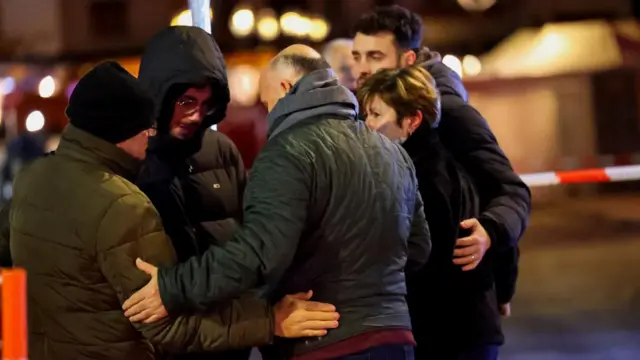 People embrace in a circle in Crans Montana