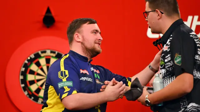 Luke Littler shakes hands with Gian van Veen