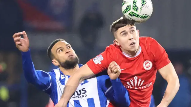 Coleraine's Charles Dunne is beaten to the high ball by Larne forward Paul O'Neill