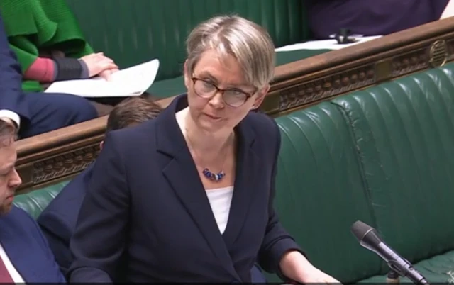 The Foreign Secretary is wearing a navy suit, and is wearing glasses as she addresses MPs questions.