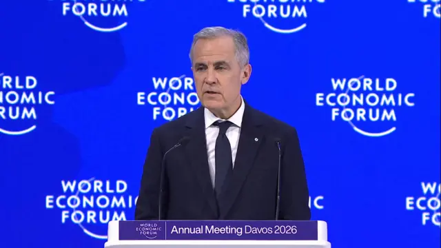 Canadian Prime Minister Mark Carney standing in front of a blue background at the World Economic Forum