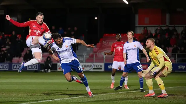 Ryan Tafazolli heads clear in the goalmouth