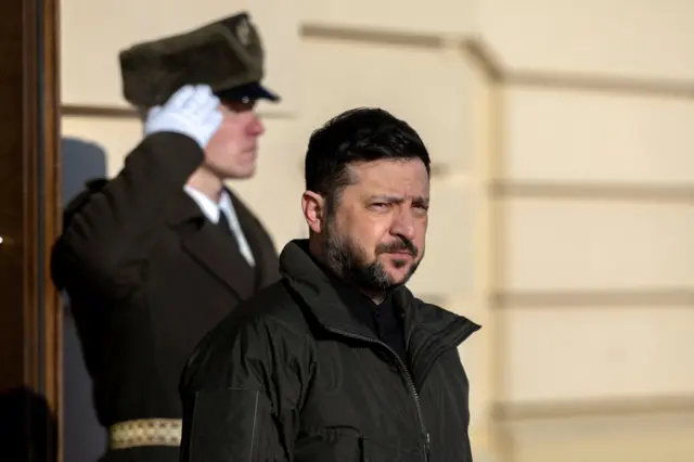 President Volodymyr Zelensky is standing outside a buidling with a security guard behind him. The photo was taken a few days ago.