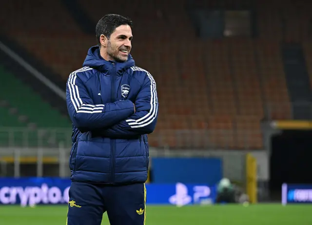 Mikel Arteta smiling with his arms folded