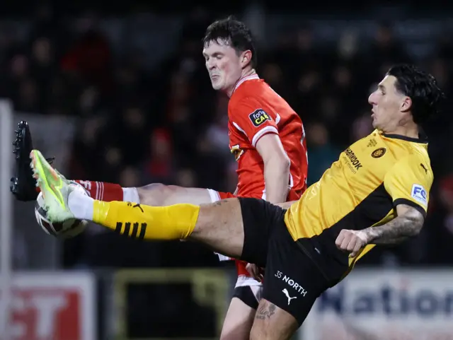 Danny Gibson challenges for the ball