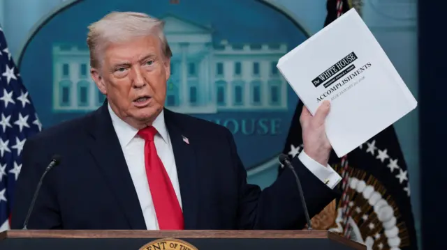 U.S. President Donald Trump holds a document with White House's accomplishments as he speaks during a press briefing at the White House, on the one-year mark into his second term in office, in Washington, D.C., U.S., January 20, 2026.