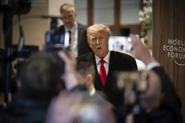 Donald Trump talks to the media after an interview at the World Economic Forum