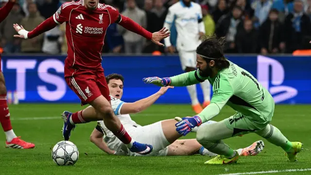Alisson dives onto a ball