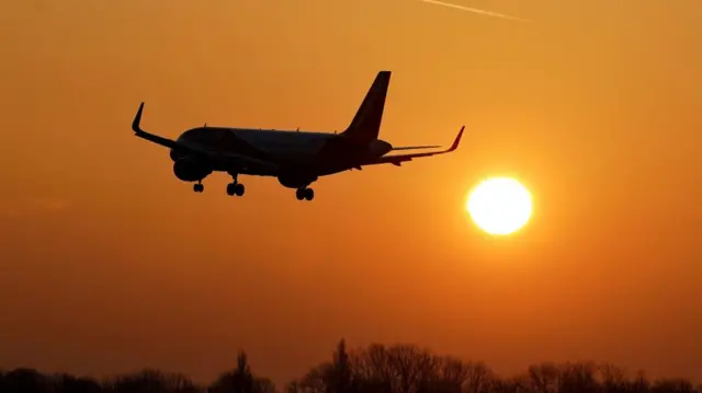 A plane coming in to land at London Gatwick Airport as the sun rises