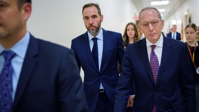 Jack Smith walks down a hallway at the Capitol