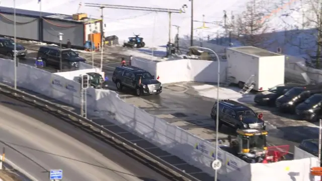 Several black people carriers drive with US flags attach drive through Davos