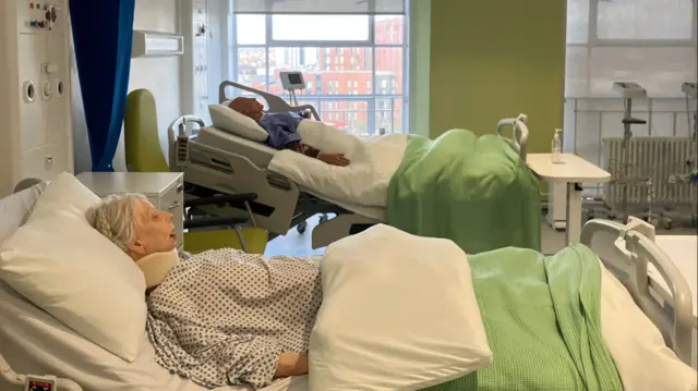 Mannequins on the simulation ward at Aston University. There is a woman and a man in hospital beds.