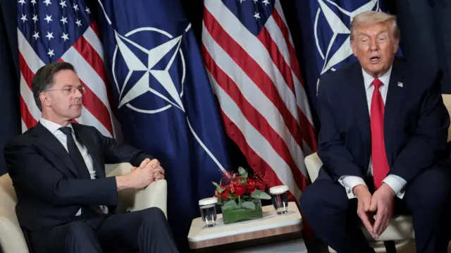 Rutte sits next to Donald Trump