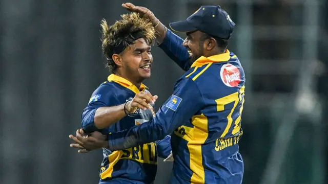 Sri Lanka's Dunith Wellalage (L) celebrates with captain Charith Asalanka after taking the wicket of England's Jacob Bethell