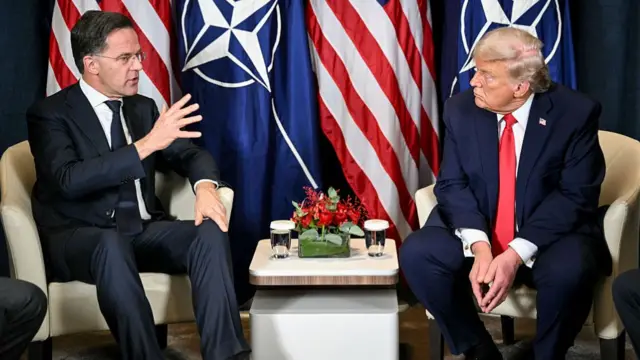 Mark Rutte and Donald Trump sit at Davos in front of Nato and US flags
