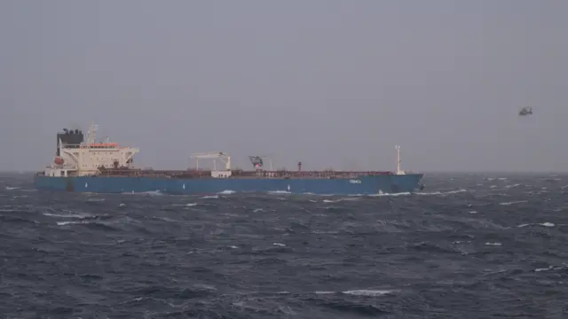 A French military handout image of the tanker Grinch - two apparently military helicopters can also be seen - one near the deck and another of the ship's bow