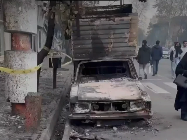 A burned out car and damaged truck in Rasht, traced back to 17 January