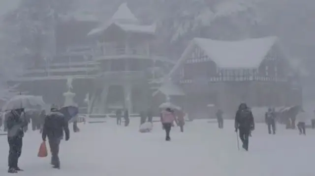 People out in a snow-covered in India's northern region
