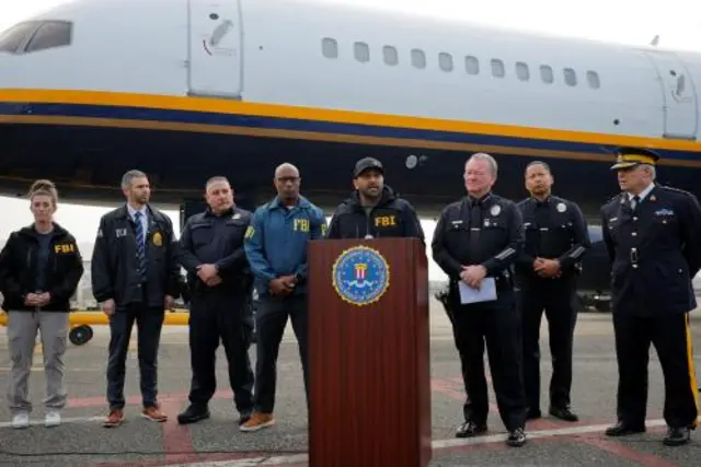 Các đặc vụ FBI xếp hàng trước một chiếc máy bay.