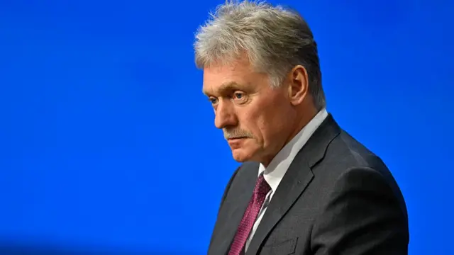 Dmitry Peskov against a blue background