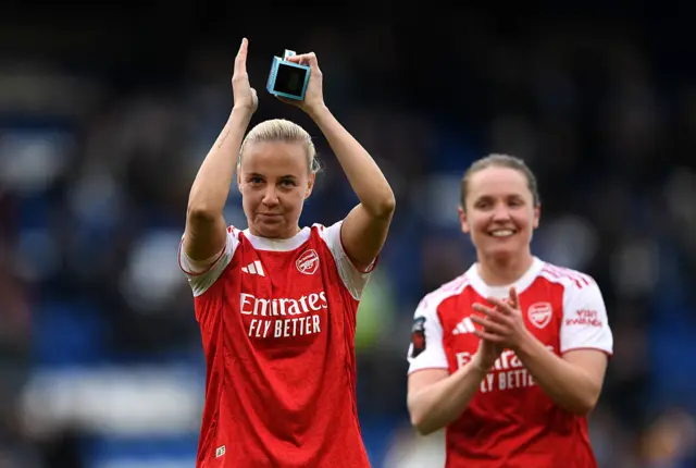 Beth Mead applauds holding her trophy while Kim Little looks on