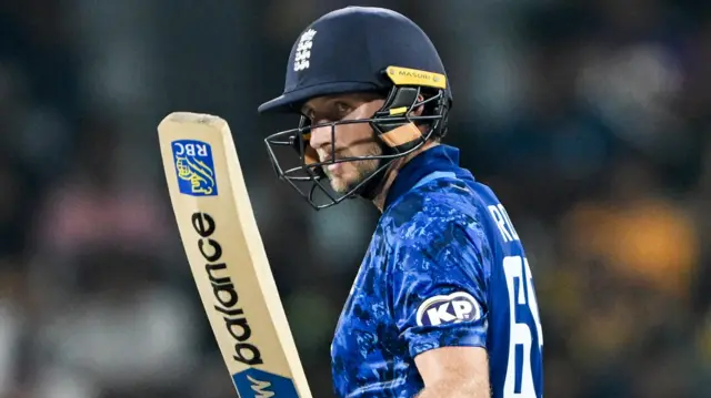 Joe Root raising his bat after hitting his 50