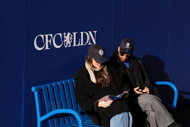 Fans look at the programme at Stamford Bridge