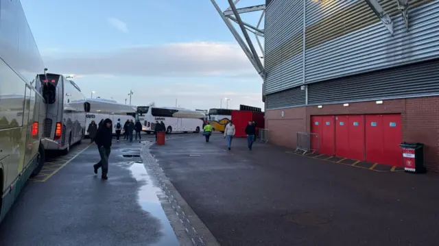 A line of buses. Very few people are around.