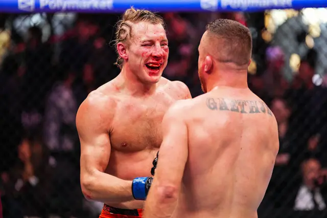 Paddy Pimblett with blood on his face shaking Justin Gaethje's hand