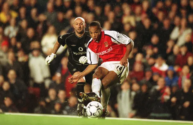 Arsenal's Thierry Henry scores as Manchester United goalkeeper Fabian Barthez looks on