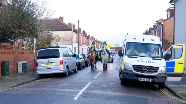Mounted police officers on a street.
