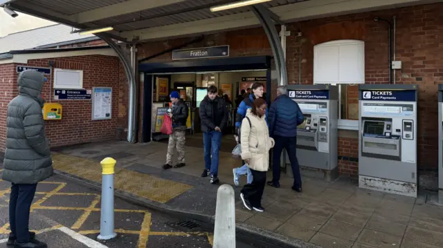 People leave a train station.